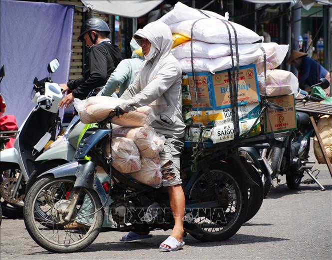 Vất vả vận chuyển hàng hóa trên đường Chương Dương - chợ Đông Ba, thành phố Huế, dưới trời nắng nóng. Ảnh: Nguyên Lý - TTXVN