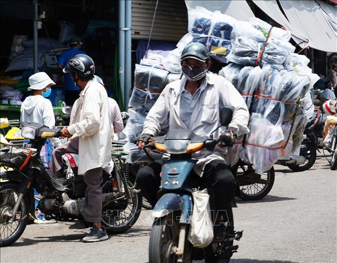 Vất vả vận chuyển hàng hóa trên đường Chương Dương - chợ Đông Ba, thành phố Huế dưới trời nắng nóng. Ảnh: Nguyên Lý - TTXVN