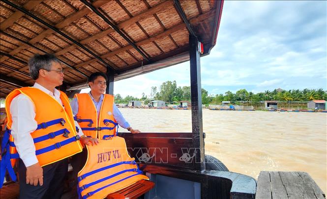 Đoàn khảo sát vùng nuôi thủy sản lồng bè tại xã An Bình. Ảnh: Lê Thúy Hằng – TTXVN
