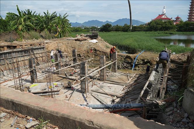 Đổ bê tông và thi công kết cấu móng, trụ cống tại khu vực cửa xả/hồ điều hòa nhằm tăng cường năng lực thoát nước cho khu vực. Ảnh: Anh Dũng - TTXVN
