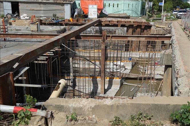 Huy động xe cơ giới, máy bơm cùng lực lượng công nhân đẩy nhanh tiến độ thi công các hạng mục cống thoát nước trọng điểm. Ảnh: Anh Dũng - TTXVN