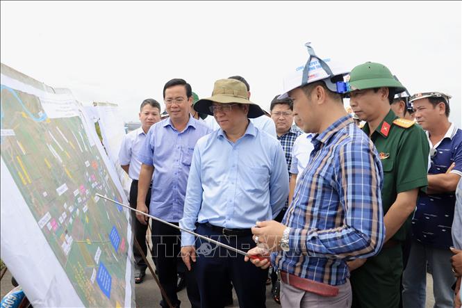 Chủ tịch UBND tỉnh An Giang Hồ Văn Mừng nghe các nhà thầu báo cáo tiến độ thi công tại nút giao Dự án thành phần 1 với Đường tỉnh 943, xã Định Mỹ. Ảnh: Thanh Sang-TTXVN