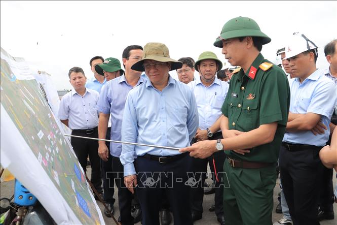 Chủ tịch UBND tỉnh An Giang Hồ Văn Mừng nghe các nhà thầu báo cáo tiến độ thi công tại nút giao Dự án thành phần 1 với Đường tỉnh 943, xã Định Mỹ. Ảnh: Thanh Sang-TTXVN