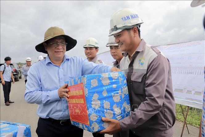Ông Hồ Văn Mừng, Chủ tịch UBND tỉnh An Giang tặng quà cho các công nhân trên công trường thi công cao tốc tại nút giao với Đường tỉnh 943, xã Định Mỹ. Ảnh: Thanh Sang-TTXVN
