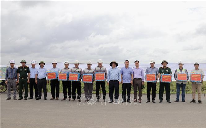 Ông Hồ Văn Mừng, Chủ tịch UBND tỉnh An Giang (thứ 7 từ bên phải qua) tặng quà cho các công nhân trên công trường thi công cao tốc tại nút giao với Đường tỉnh 943, xã Định Mỹ. Ảnh: Thanh Sang-TTXVN
