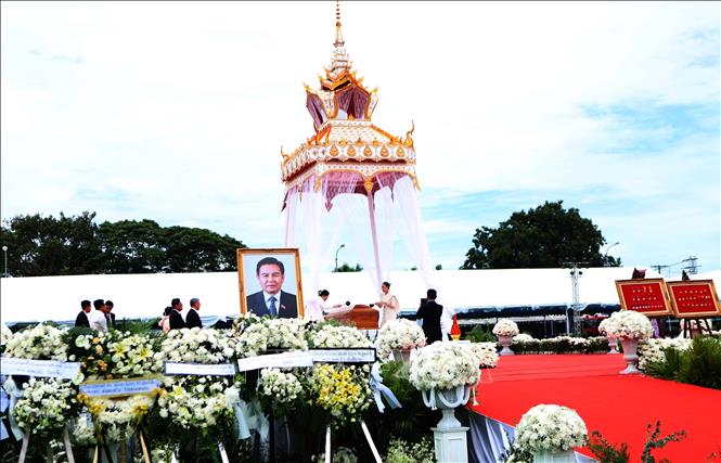 Gia quyến đồng chí Xaysomphone Phomvihane thực hiện nghi thức tưới nước cầu siêu thoát. Ảnh: Xuân Tú - PV TTXVN tại Lào