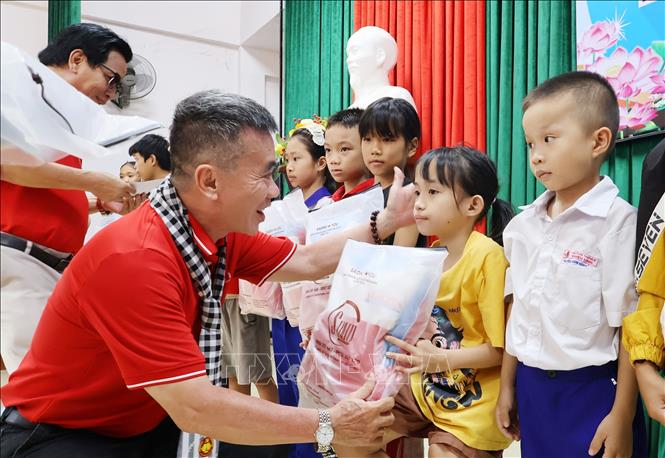 Đại diện Hội Nhà báo Thành phố Hồ Chí Minh tặng quà, trao học bổng cho học sinh nghèo vượt khó xã Ải Tử, tỉnh Quảng Trị. Ảnh: Đinh Hằng - TTXVN