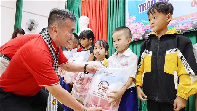Đại diện Hội Nhà báo Thành phố Hồ Chí Minh tặng quà, trao học bổng cho học sinh nghèo vượt khó xã Ải Tử, tỉnh Quảng Trị. Ảnh: Đinh Hằng - TTXVN