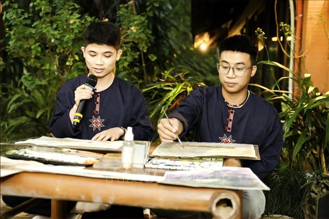 Nhân viên Panhou Retreat giới thiệu hoạt động vẽ tranh truyền thống tới du khách. Ảnh: Minh Tâm -TTXVN