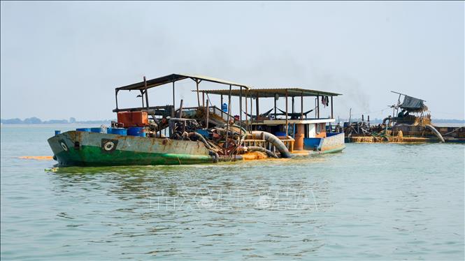 Các phương tiện khai thác, vận chuyển cát trên hồ Dầu Tiếng. Ảnh: Minh Phú - TTXVN 