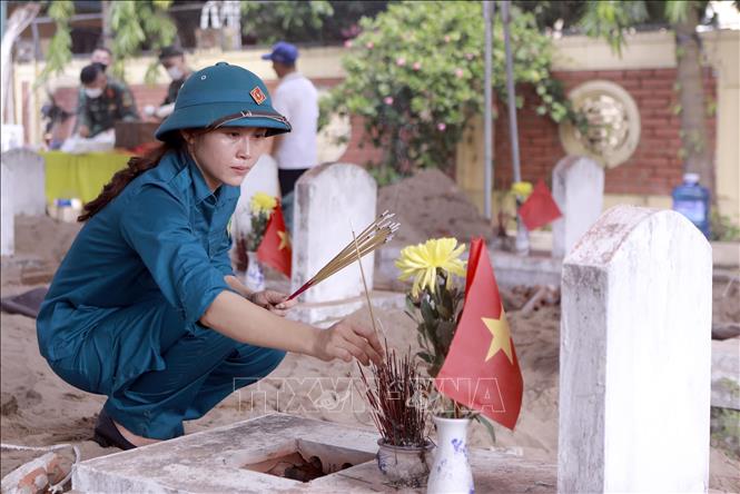 Nữ dân phòng xã Vĩnh Thành xúc động thắp hương tưởng niệm trước phần mộ liệt sĩ tại Nghĩa trang Liệt sĩ Cao Đại. Ảnh: Hoàng Hùng - TTXVN