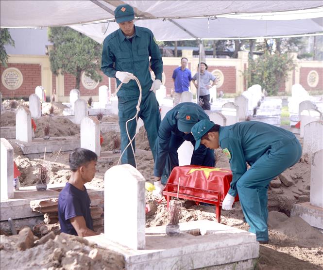 Tiểu đựng hài cốt liệt sĩ sau khi lấy mẫu sinh phẩm được đưa trở lại phần mộ tại Nghĩa trang Liệt sĩ Cao Đại, xã Vĩnh Thành. Ảnh: Hoàng Hùng - TTXVN