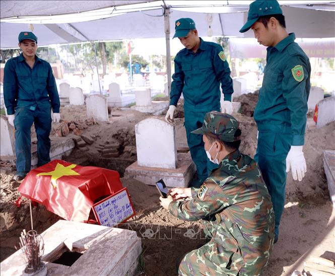 Số hóa thông tin các phần mộ liệt sĩ trong quá trình lấy mẫu sinh phẩm tại Nghĩa trang Liệt sĩ Cao Đại, xã Vĩnh Thành. Ảnh: Hoàng Hùng - TTXVN
