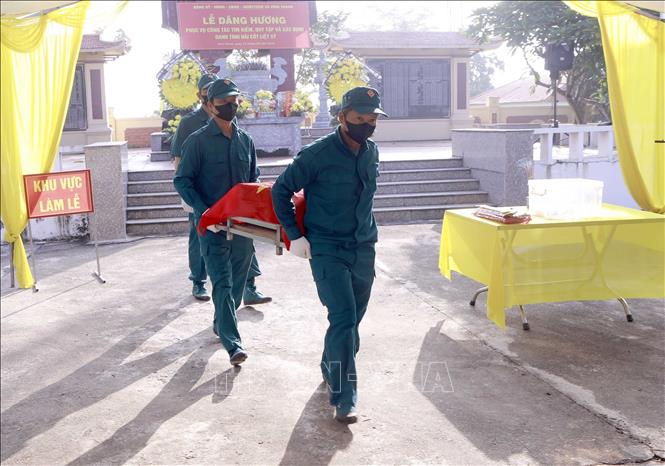 Lực lượng dân quân xã Vĩnh Thành đưa hài cốt liệt sĩ đến khu vực lấy mẫu sinh phẩm tại Nghĩa trang Liệt sĩ Cao Đại, xã Vĩnh Thành. Ảnh: Hoàng Hùng - TTXVN
