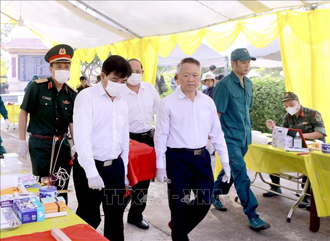 Lãnh đạo xã Vĩnh Thành di chuyển hài cốt liệt sĩ tới bàn lấy mẫu tại Nghĩa trang Liệt sĩ Cao Đại, xã Vĩnh Thành. Ảnh: Hoàng Hùng - TTXVN