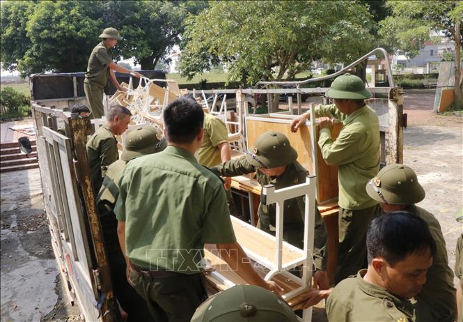 Các lực lượng hỗ trợ Trường Tiểu học Phú Hòa di dời đến nơi học tạm. Ảnh: Thanh Thương - TTXVN