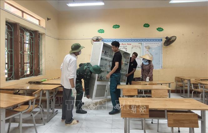 Các lực lượng hỗ trợ Trường Tiểu học Phú Hòa di dời đến nơi học tạm. Ảnh: Thanh Thương - TTXVN