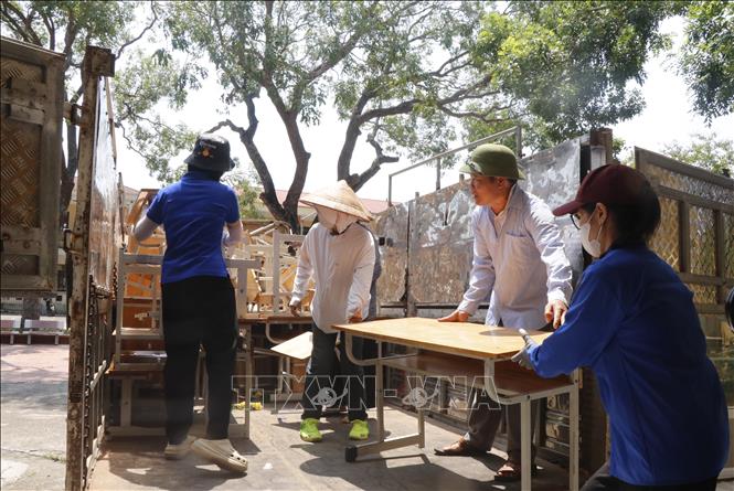 Các lực lượng hỗ trợ Trường Tiểu học Phú Hòa di dời đến nơi học tạm. Ảnh: Thanh Thương - TTXVN