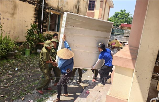 Các lực lượng hỗ trợ Trường Tiểu học Phú Hòa di dời đến nơi học tạm. Ảnh: Thanh Thương - TTXVN