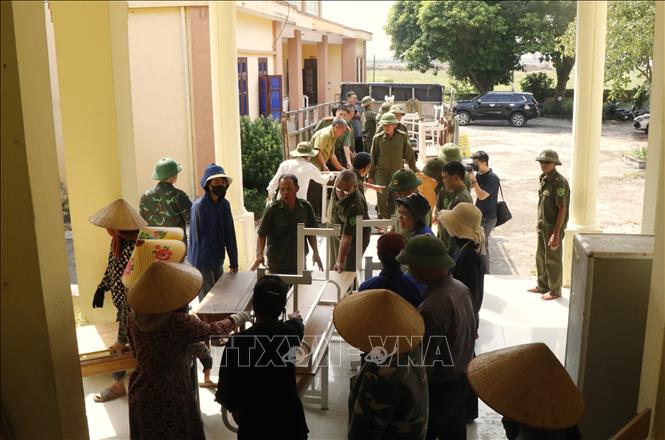 Các lực lượng hỗ trợ Trường Tiểu học Phú Hòa di dời đến nơi học tạm. Ảnh: Thanh Thương - TTXVN