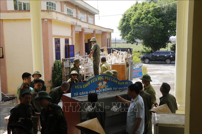 Các lực lượng hỗ trợ Trường Tiểu học Phú Hòa di dời đến nơi học tạm. Ảnh: Thanh Thương - TTXVN