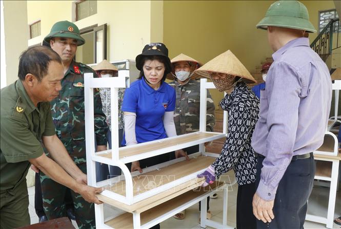 Các lực lượng hỗ trợ Trường Tiểu học Phú Hòa di dời đến nơi học tạm. Ảnh: Thanh Thương - TTXVN