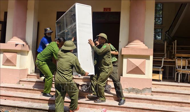 Các lực lượng hỗ trợ Trường Tiểu học Phú Hòa di dời đến nơi học tạm. Ảnh: Thanh Thương - TTXVN