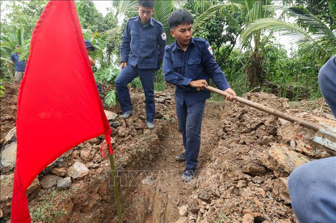 Khi phát hiện dấu vết nghi là nơi chôn cất liệt sĩ, lá cờ đỏ sẽ được cắm lên để đánh dấu. Ảnh: Hồng Thái - TTXVN