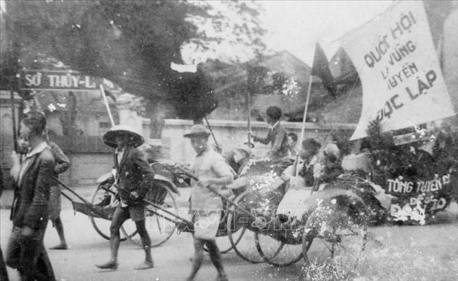 Thông qua các đoàn thể cứu quốc, Mặt trận Việt Minh đã tuyên truyền, vận động quần chúng tự nguyện và hăng hái tham gia các phong trào sản xuất, cứu đói, hũ gạo tiết kiệm, tuần lễ vàng, bình dân học vụ... nhằm phát huy tinh thần yêu nước của Nhân dân để vượt qua những khó khăn về kinh tế, tài chính. Trong ảnh: Nhân dân lao động Thủ đô cổ động cho ngày Tổng tuyển cử đầu tiên. Ảnh: TTXVN