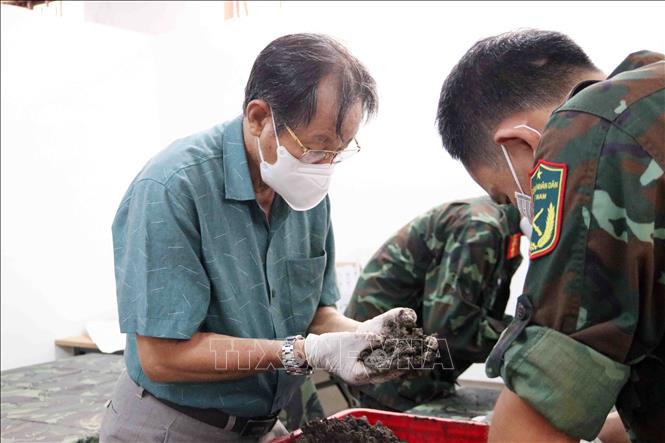 Cẩn trọng, tỉ mỉ, chu đáo tìm kiếm những phần di cốt còn lại của liệt sĩ. Ảnh: Xuân Khu-TTXVN