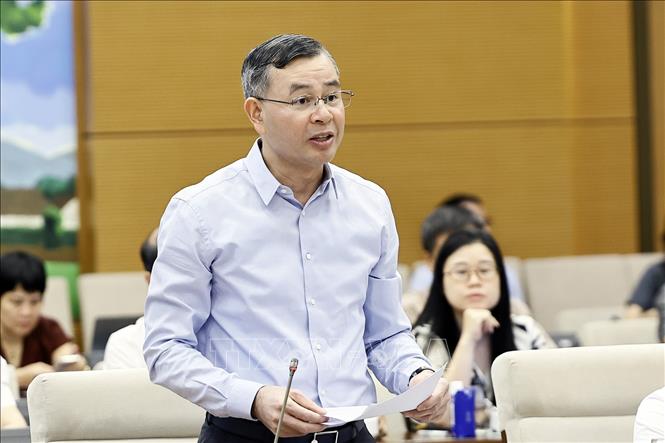 Bộ trưởng Bộ Tài chính Ngô Văn Tuấn trình bày báo cáo tiếp thu, giải trình và chỉnh lý các dự thảo. Ảnh: Doãn Tấn - TTXVN
