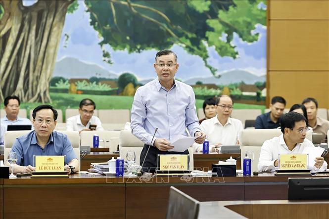 Bộ trưởng Bộ Tài chính Ngô Văn Tuấn trình bày báo cáo tiếp thu, giải trình và chỉnh lý các dự thảo. Ảnh: Doãn Tấn - TTXVN