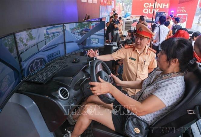 Người dân tham gia trải nghiệm lái xe thực tế ảo tại khu vực của Cảnh sát giao thông  trong sự kiện 