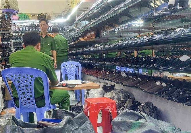Cơ quan chức năng kiểm tra cửa hàng giày dép do Phạm Văn Tân làm chủ. Ảnh: TTXVN phát