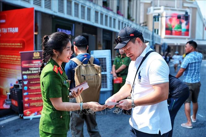Cán bộ Công an giới thiệu, hướng dẫn người dân tìm hiểu các tiện ích của mô hình Kiosk “Trạm Cảnh sát thông minh”. Ảnh: Phạm Tuấn Anh - TTXVN