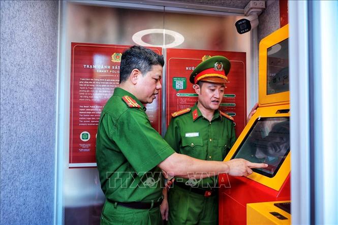Thượng tá Nguyễn Thành Lâm (bên trái) cùng cán bộ Công an trải nghiệm hoạt động của Kiosk “Trạm Cảnh sát thông minh” trước khi đưa vào phục vụ người dân. Ảnh: Phạm Tuấn Anh - TTXVN