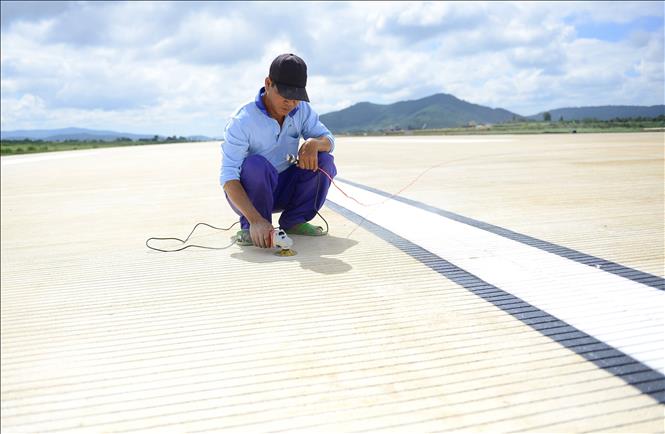 Công nhân hoàn thành chỉnh trang từng phần nhỏ nhất để đảm bảo mặt đường cất - hạ cánh mới có chất lượng tốt nhất. Ảnh: Nguyễn Dũng – TTXVN
