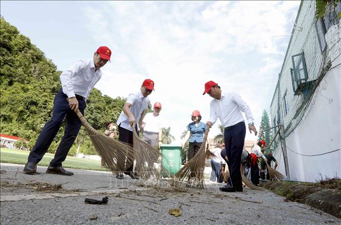 Đại biểu tham gia dọn vệ sinh môi trường tại phường Mộc Sơn. Ảnh: Quang Quyết - TTXVN