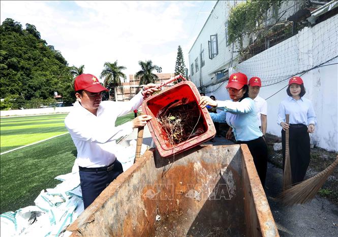 Đại biểu tham gia dọn vệ sinh môi trường tại khu vực sân vận động phường Mộc Sơn. Ảnh: Quang Quyết - TTXVN