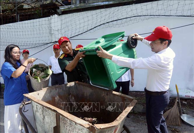 Đại biểu tham gia dọn vệ sinh môi trường tại phường Mộc Sơn. Ảnh: Quang Quyết - TTXVN