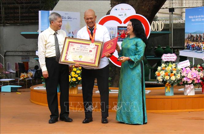 Nghệ sĩ Nhiếp ảnh Nguyễn Á nhận bằng xác nhận kỷ lục Việt Nam. Ảnh: Hương Giang - TTXVN