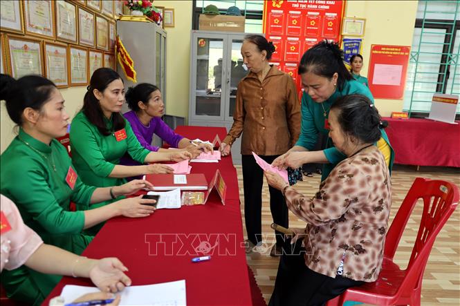 Những người làm công tác bầu cử trưởng khu phố Giếng Khe, phường Hiệp Hòa, tỉnh Quảng Ninh hướng dẫn cử tri đại diện hộ gia đình bầu cử trưởng khu phố. Ảnh: Đức Hiếu - TTXVN