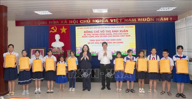 Phó Chủ tịch nước Võ Thị Ánh Xuân và Bí thư Tỉnh ủy An Giang Lê Quang Tùng tặng quà cho học sinh giỏi trên địa bàn xã Mỹ Hòa Hưng - quê hương của Chủ tịch Tôn Đức Thắng - trước thềm năm học mới. Ảnh: Công Mạo - TTXVN