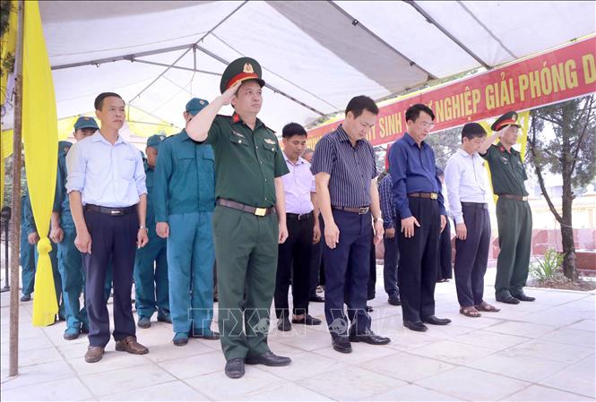 Lãnh đạo xã Hợp Lý và đại biểu tưởng niệm các liệt sĩ trước khi thực hiện lấy mẫu tại Nghĩa trang liệt sĩ Hợp Lý. Ảnh: Hoàng Hùng - TTXVN
