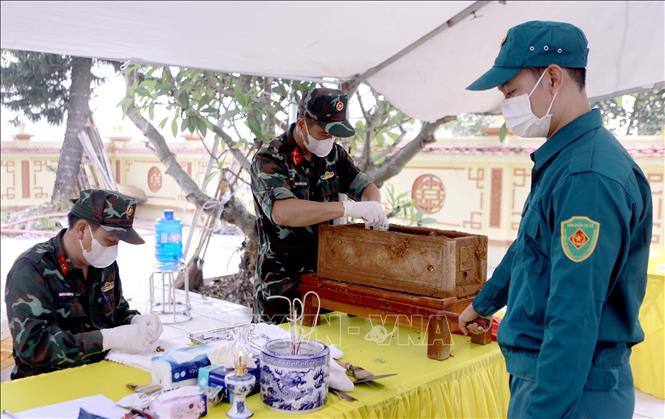 Việc lấy mẫu hài cốt liệt sĩ được tiến hành đúng quy trình kỹ thuật tại Nghĩa trang liệt sĩ Hợp Lý, xã Hợp Lý. Ảnh: Hoàng Hùng - TTXVN
