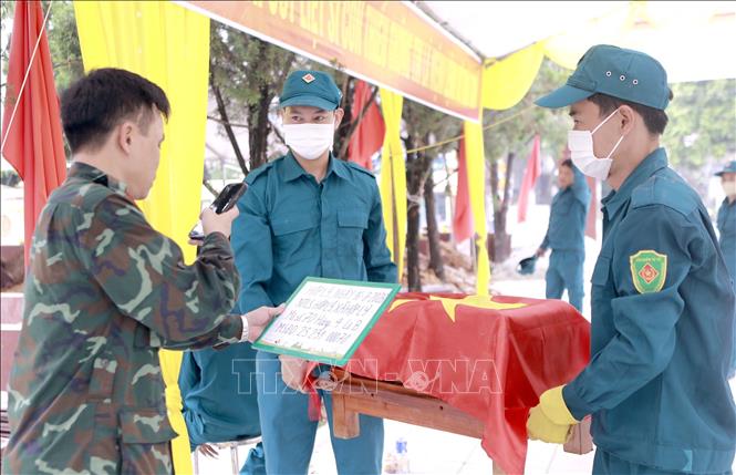 Cán bộ chuyên môn cập nhật thông tin mộ liệt sĩ trong quá trình lấy mẫu tại Nghĩa trang liệt sĩ Hợp Lý, xã Hợp Lý. Ảnh: Hoàng Hùng - TTXVN