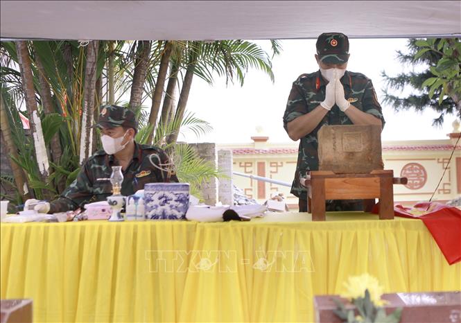 Cán bộ thực hiện nghi thức tưởng niệm trước khi lấy mẫu hài cốt liệt sĩ tại Nghĩa trang liệt sĩ Hợp Lý, xã Hợp Lý. Ảnh: Hoàng Hùng - TTXVN