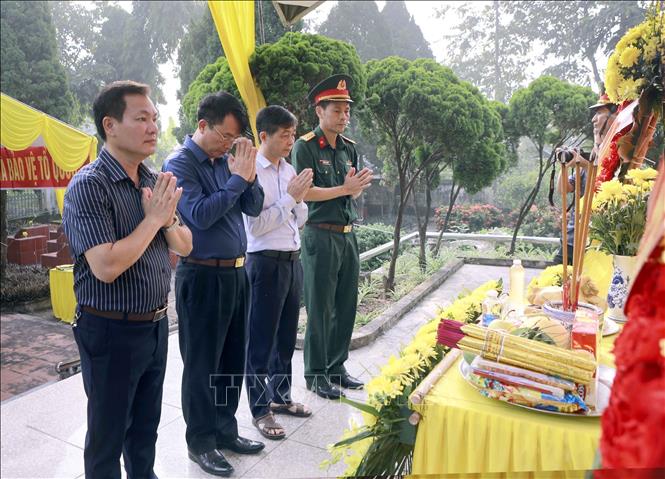 Lãnh đạo xã Hợp Lý chắp tay tưởng niệm các anh hùng liệt sĩ tại Đài tưởng niệm Nghĩa trang Liệt sĩ Ngọc Mỹ trước khi thực hiện lấy mẫu hài cốt liệt sĩ. Ảnh: Hoàng Hùng - TTXVN