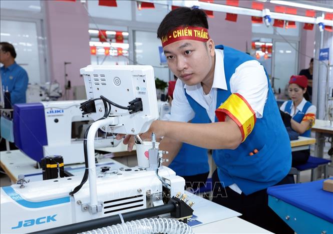 Thí sinh đến từ đội thi Tổng Công ty may 10 thi may quần âu. Ảnh: Trần Việt - TTXVN