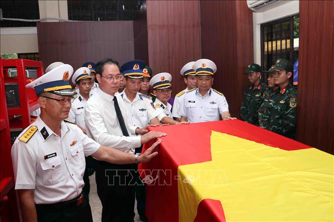 Lãnh đạo Ủy ban MTTQ Việt Nam Thành phố và đại diện lực lượng hải quân, cảnh sát biển xúc động bên hòm quàn hài cốt liệt sĩ tập thể tìm thấy tại công viên Lê Thị Riêng. Ảnh: Xuân Khu-TTXVN